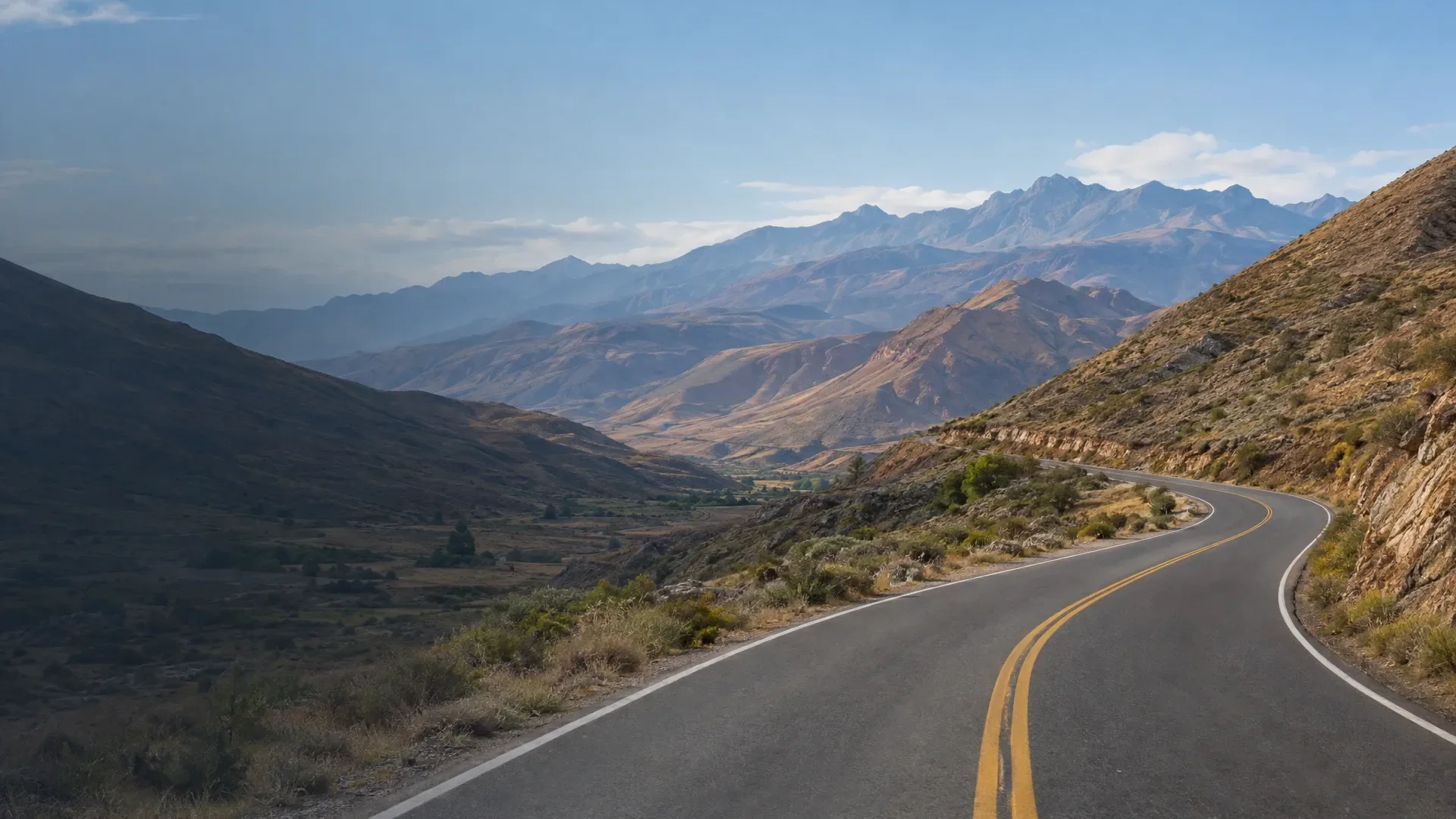 Illustration of a road through mountain scenery; not a specific route.